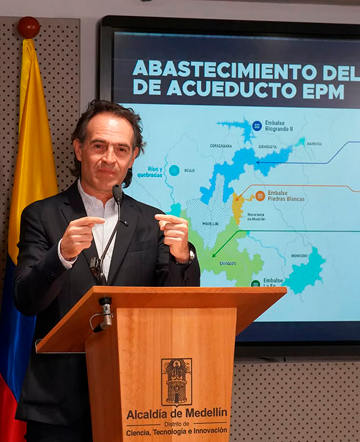 Federico Gutiérrez en atril de la Alcaldía de Medellín junto a mapa de abastecimiento de agua EPM.