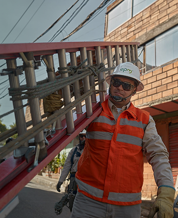 Trabajador de EPM con casco y chaleco reflectivo supervisa labores de mantenimiento en infraestructura eléctrica.