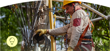Funcionario de EPM realiza mantenimiento sobre poste de energía eléctrica, acompañado de un icono de bombilla