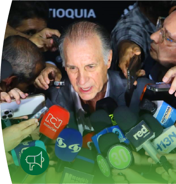 Fotografía del gerente general de EPM John Maya, habla mientras es rodeado por numerosos periodistas que le acercan micrófonos, grabadoras y teléfonos móviles