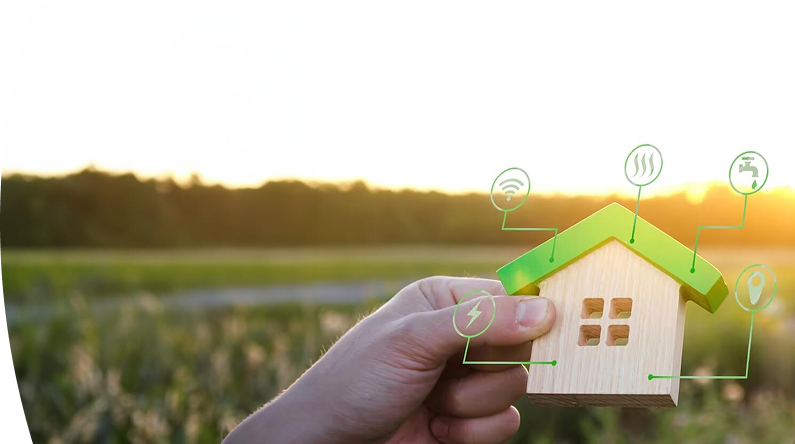 Mano sosteniendo una casa de madera en miniatura con íconos que representan servicios como electricidad, agua, gas, internet e iluminación