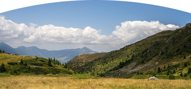 Montañas vedes y un campo en un día soleado