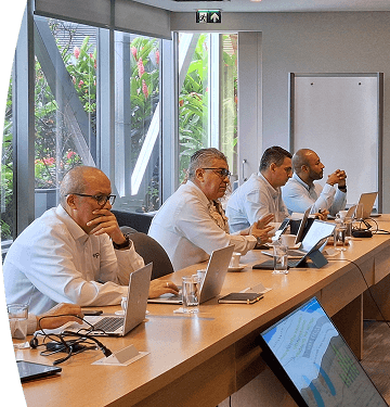 Equipo de trabajo en reunión analizando indicadores y gráficos de generación en una pantalla, en entorno corporativo.