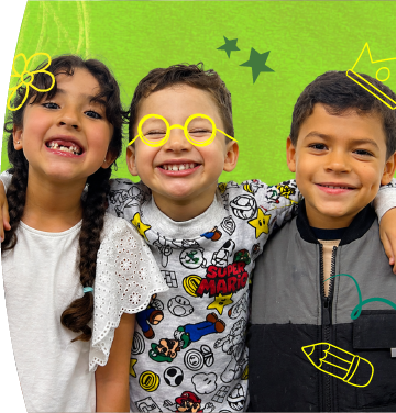 Tres niños sonriendo abrazados con dibujos infantiles de coronas y estrellas sobre un fondo verde y violeta.