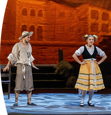 Presentación teatral con dos actores caracterizados en una escena ambientada en una época histórica