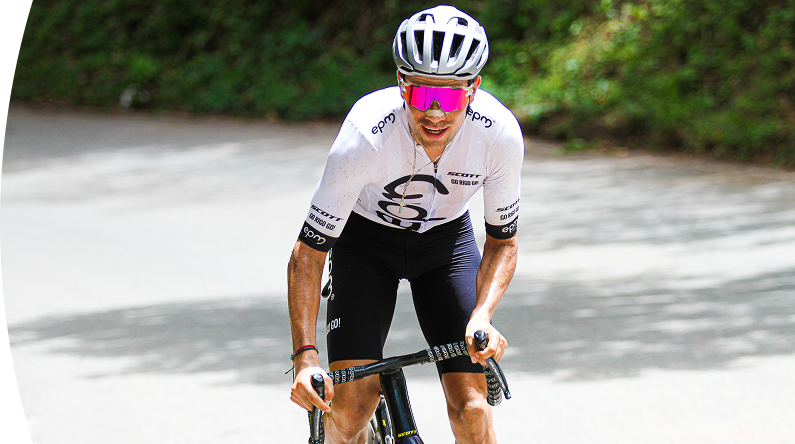 Ciclista con uniforme de EPM participando en una competencia deportiva en carretera
