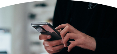 Person holding and using a mobile phone.