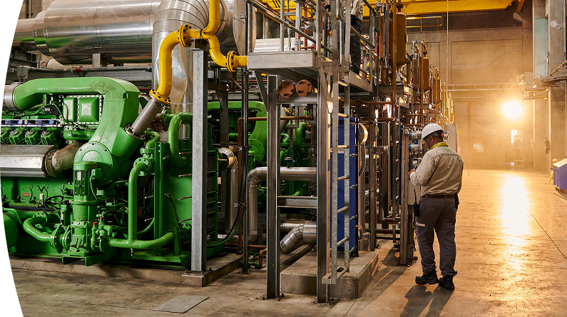 Trabajador EPM revisando una máquina dentro de una fábrica