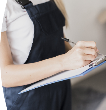 Persona escribiendo con bolígrafo en una hoja sujetada por un portapapeles azul