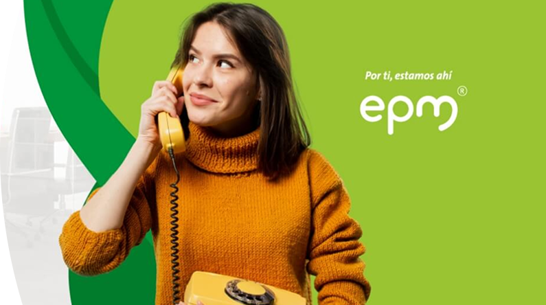 Mujer con suéter naranja sostiene un teléfono fijo amarillo y sonríe