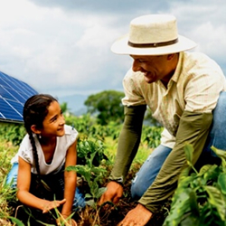 Hombre y una niña en un entorno rural con paneles solares