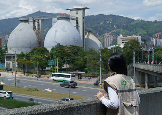 Trabajadora de EPM observa los biodigestores de la planta de tratamiento en Medellín desde un puente