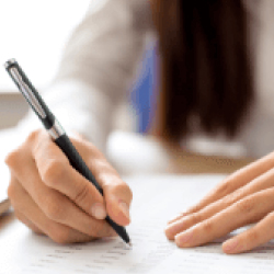 Persona escribiendo con bolígrafo sobre un documento