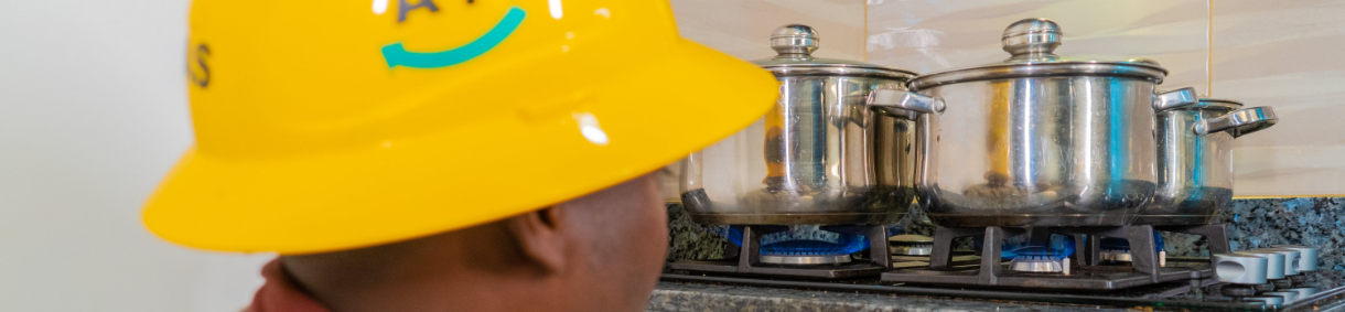 Conoce cómo hacer un uso eficiente de lo servicios públicos. Imagen de estufa de gas con una olla cociendo sobre una llama de gas azul.