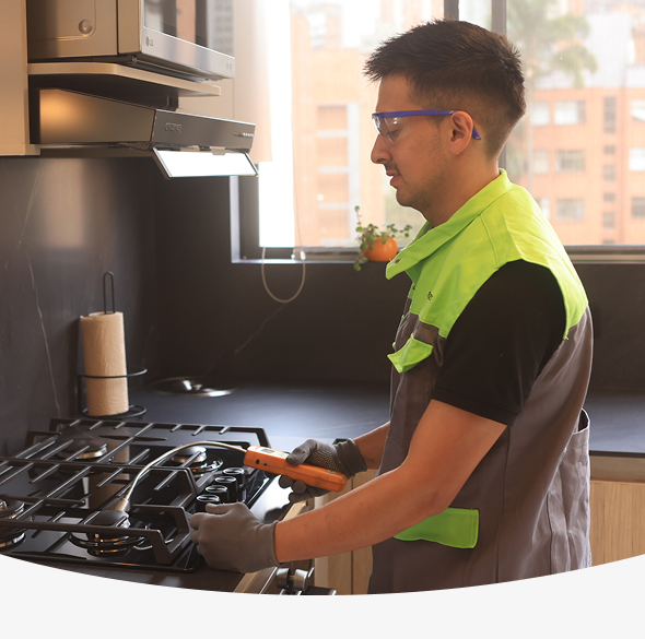 Fotografía de funcionario de epm a tu puerta revisando los fogones de la estufa