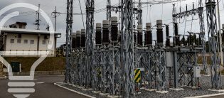 Instalaciones eléctricas en un centro de distribución de energía, con torres y equipos eléctricos visibles, bajo un cielo nublado.