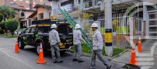 Cuadrilla de EPM realiza trabajos de mantenimiento en red eléctrica urbana con vehículo técnico.