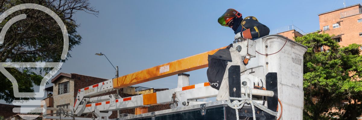 Técnico electricista en una plataforma de trabajo, realizando tareas de reparación en una zona residencial.