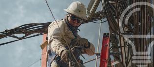 Operario de EPM realizando mantenimiento de redes eléctricas en altura con equipo de seguridad