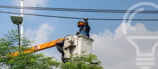 Trabajador de EPM en cesta elevadora arreglando cables.