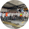 Grupo de trabajadores de EPM posando para una foto con ropa de trabajo y camión de fondo