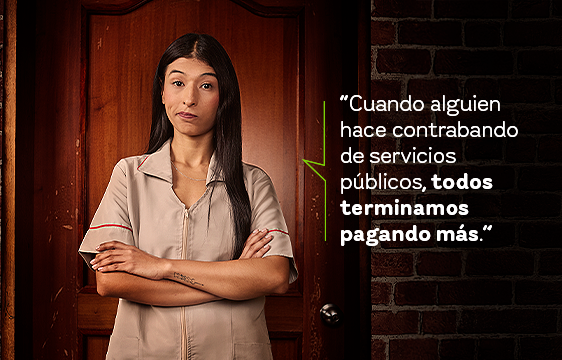 Mujer con los brazos cruzados y haciendo gesto de desagrado. Al fondo se observan ladrillos y puerta de madera