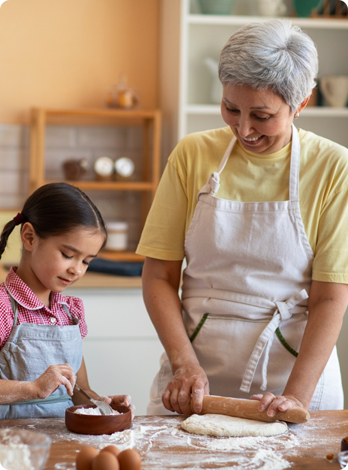 Fotografía de abuela y su nieta cocinando muy felices y seguras