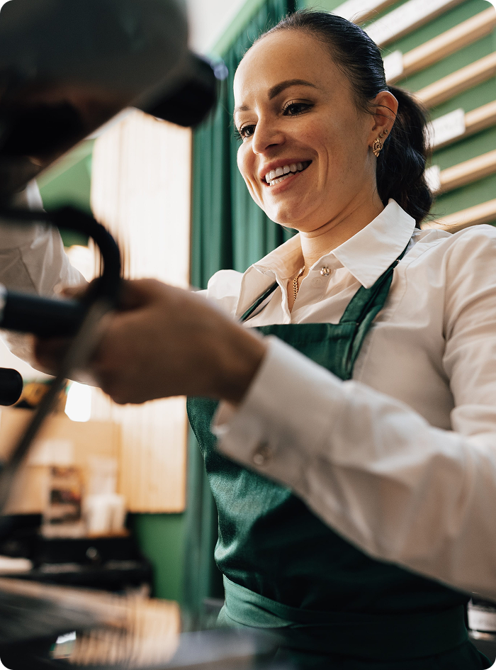mujer sirviendo un café en su trabajo feliz