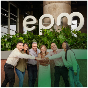 Personas posando para la foto frente al logo de EPM