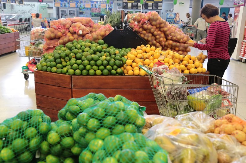 Sección de frutas y verduras con limones, cebollas y papas en exhibición
