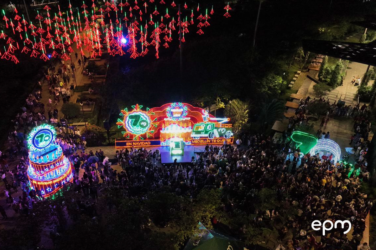 Fotografía del área del alumbrado de navideño 2025 de epm, se ve un pastel de cumpleaños, la frase "En navidad medellín te quiere" y el logo de los 70 años de epm