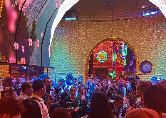 Personas reunidas en el alumbrado del castillo con el escudo de Medellín