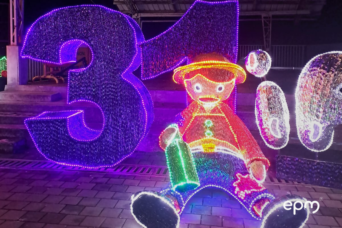 Figura navideña de persona con sombrero recostada sobre figura navideña del número 31