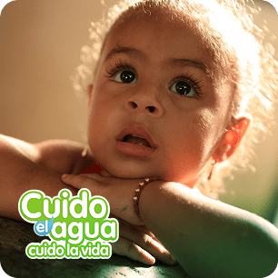 Fotografía de niña mirando con atención hacia arriba, acompañada con un sello que dice: "Cuido el agua, cuido la vida."