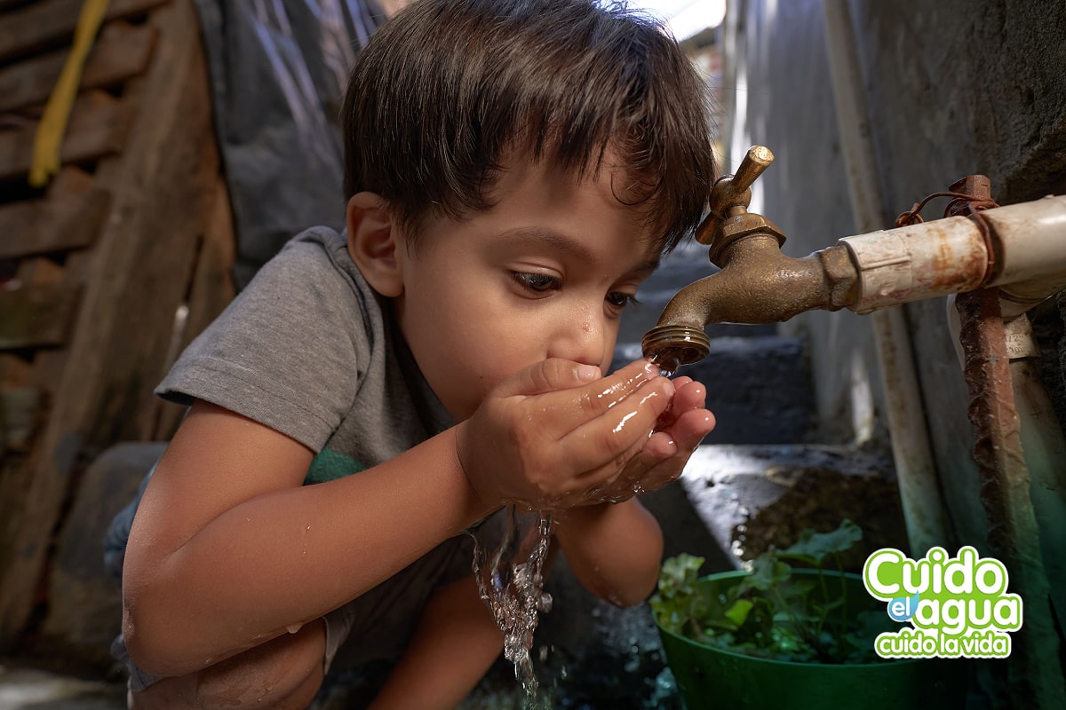 Fotografía de niño tomado agua del grifo, acompañadas de un sello que dice "Cuido el agua, cuido la vida"