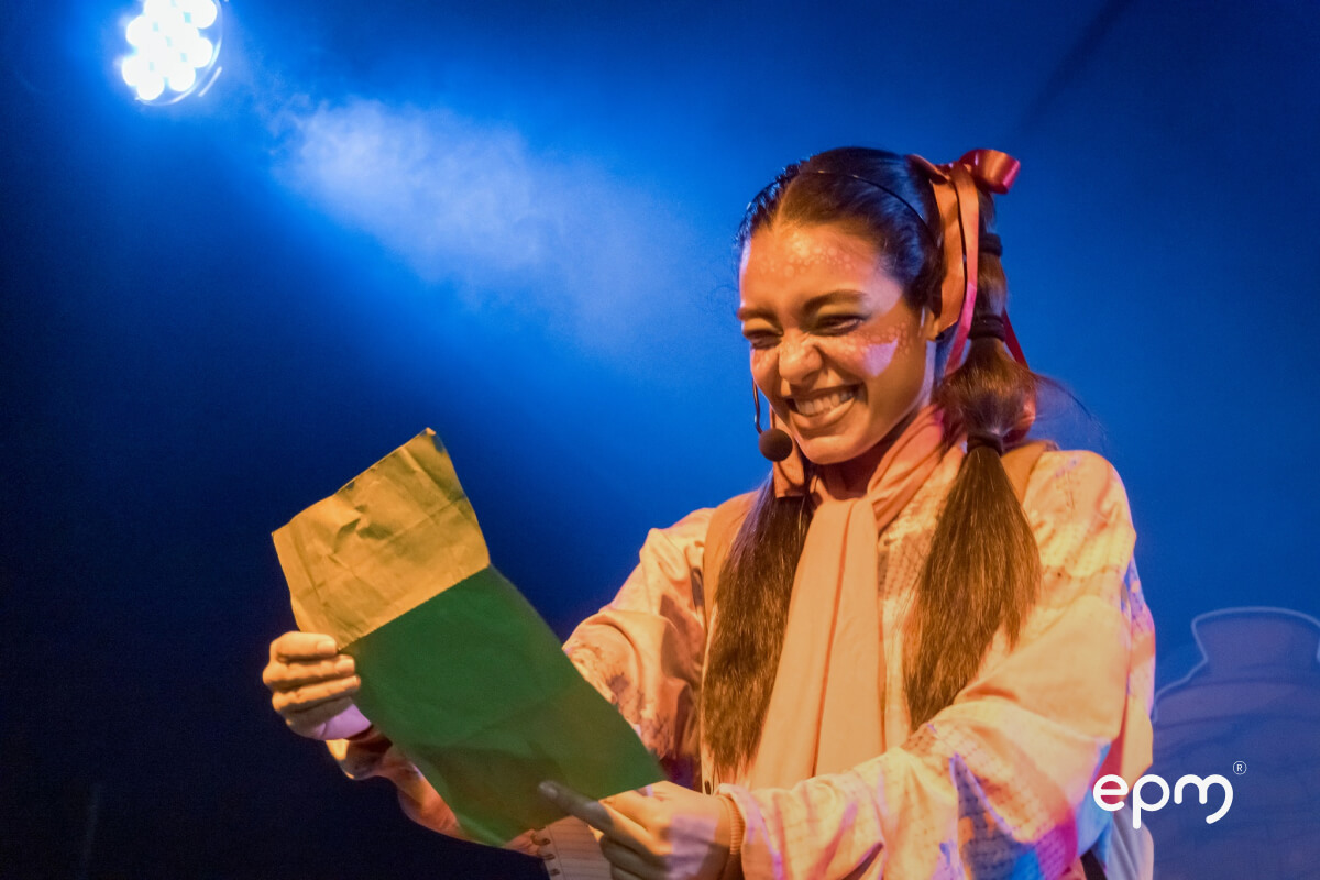 Fotografía de una mujer sonriedno mientras lee una carta