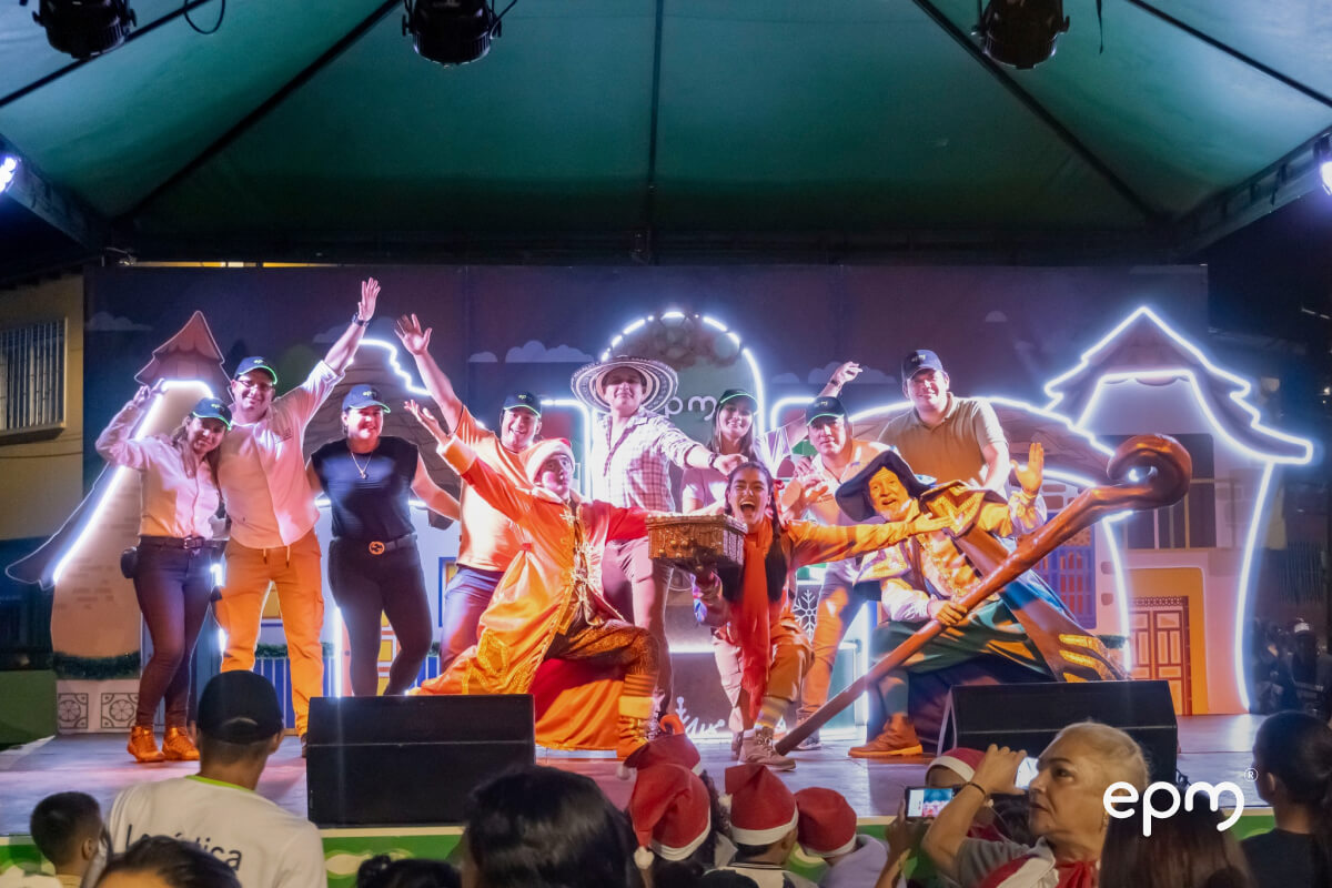 Fotografía de personas reunidas en un escenario con disfraces navideños