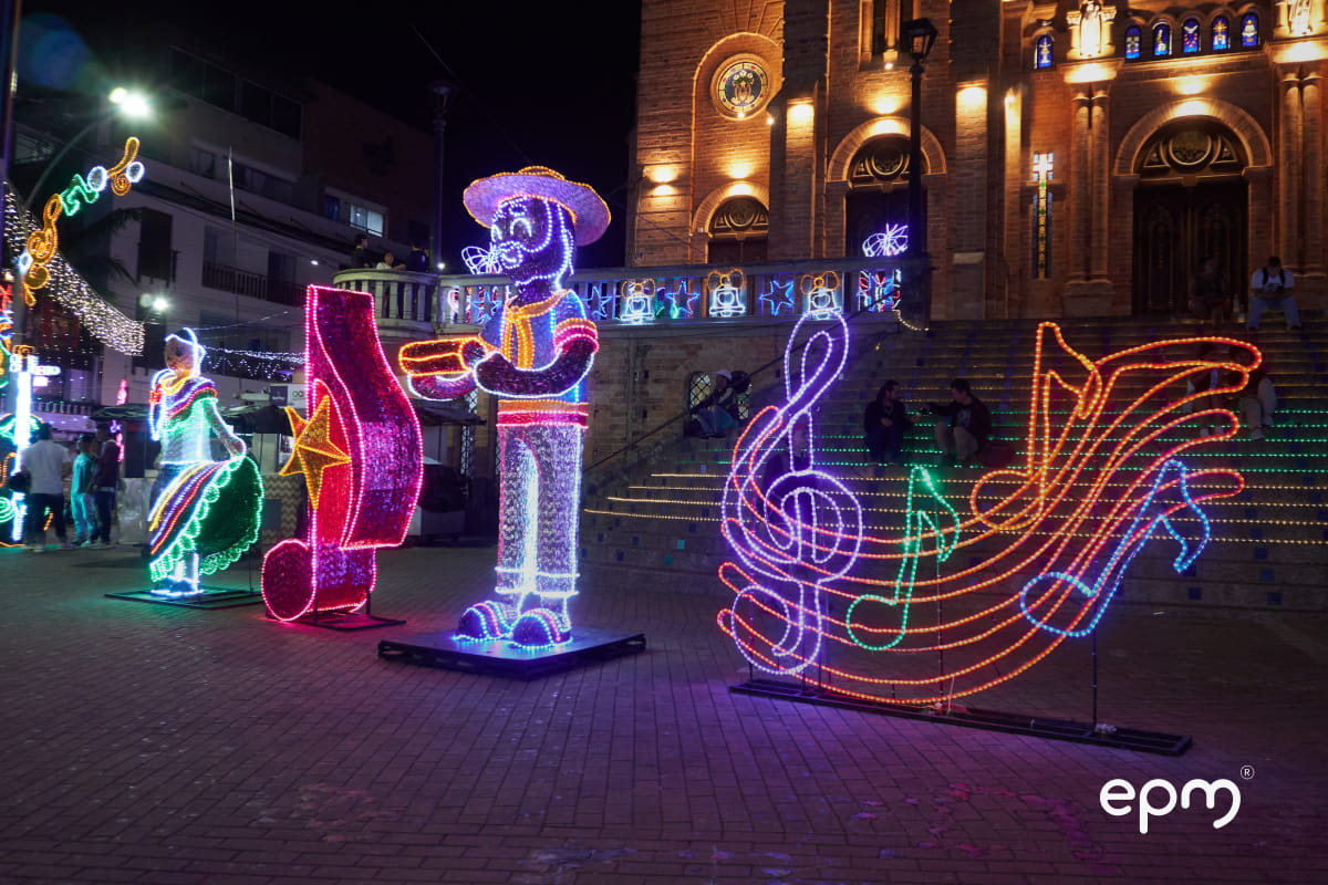Figuras navideñas musicales en el parque central, de fondo se distingue la iglesia iluminada