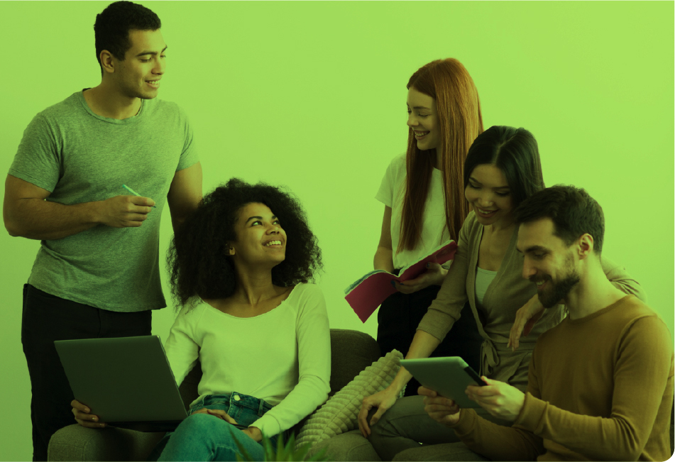 Grupo de jóvenes reunidos en un ambiente colaborativo, usando computador portátil y tableta mientras comparten ideas y sonríen.