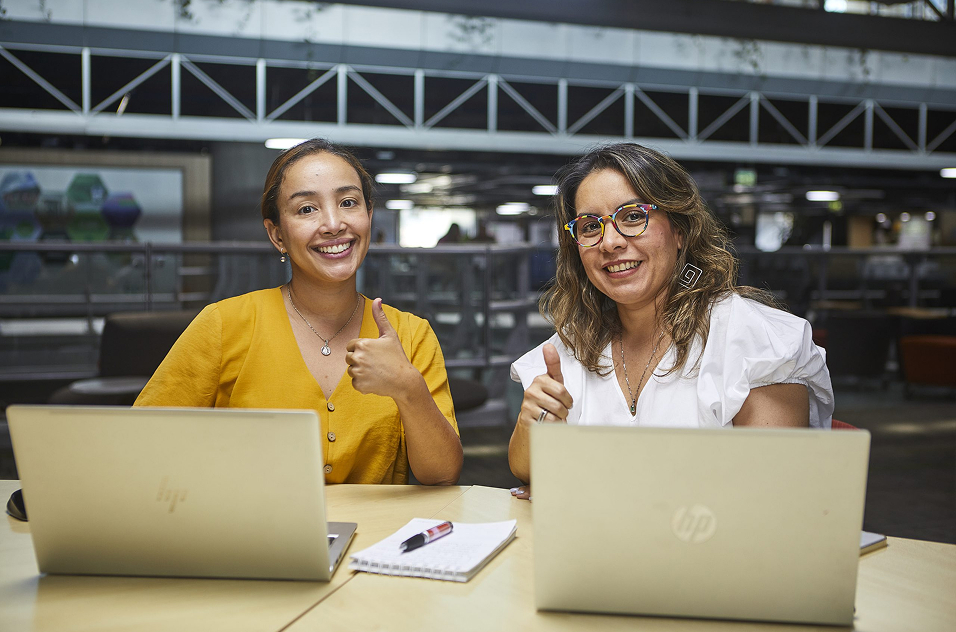 Trabajadoras de EPM sonríen y levantan sus pulgares como señal de aprobación