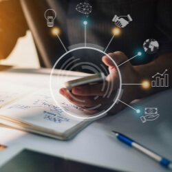 Persona usando un celular en espacio de trabajo con íconos de innovación, tecnología, finanzas y crecimiento empresarial