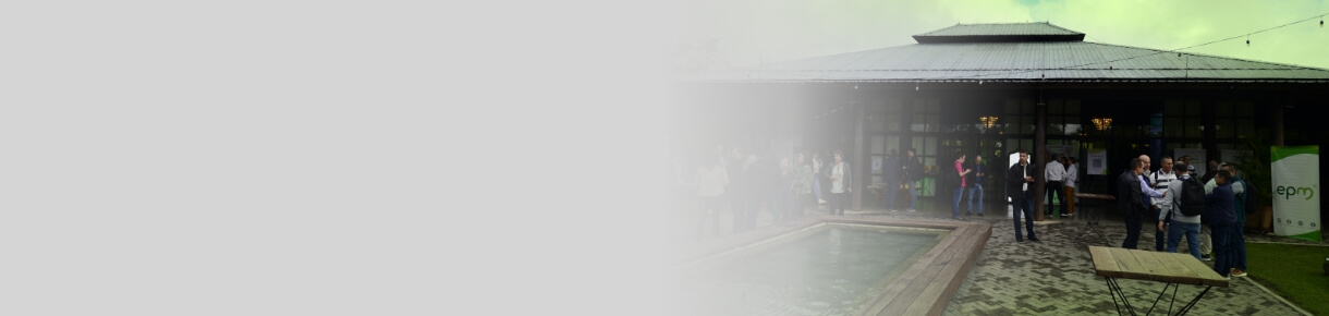 Grupo de asistentes conversando en la entrada del Pabellón Verde durante el evento Innovar EPM 2025, con entorno natural y luces ambientales