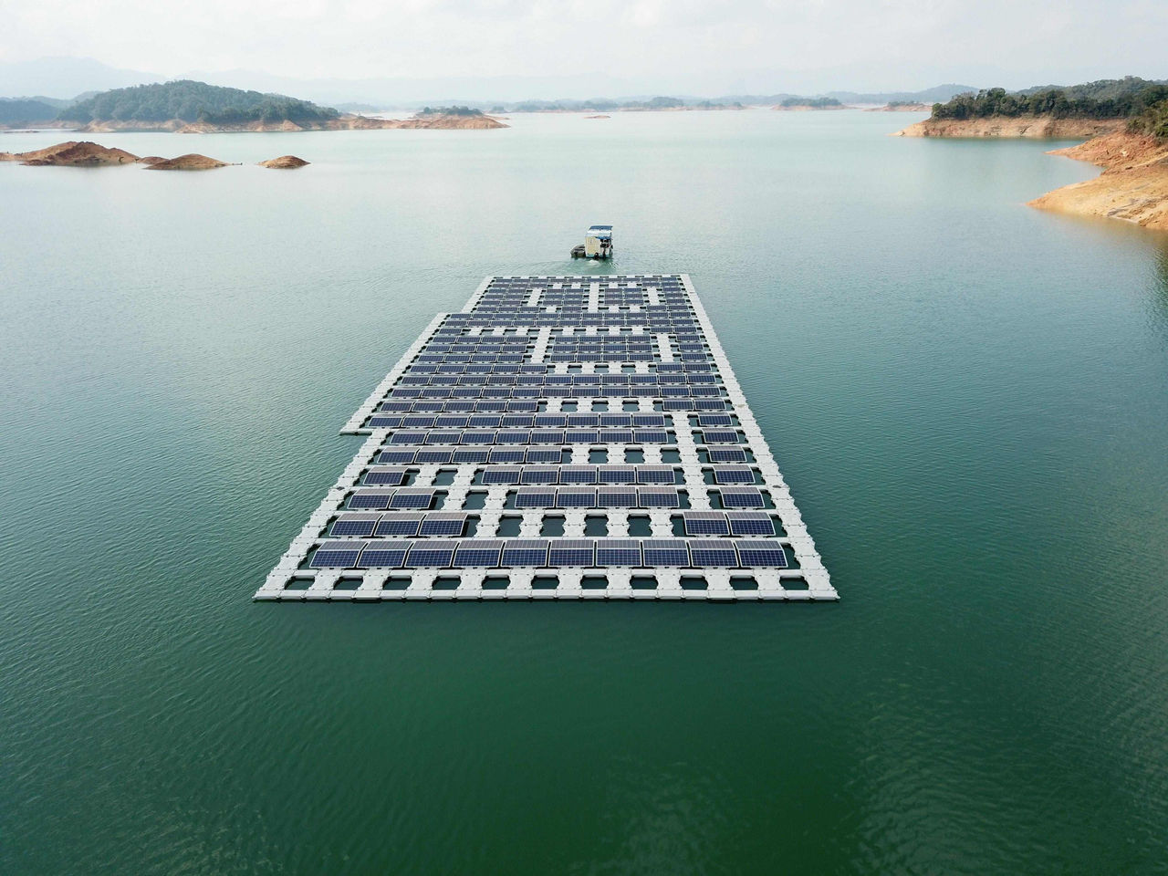 Plataforma de paneles solares flotantes de EPM en embalse, generando energía solar renovable en un entorno natural de aguas tranquilas y montañas