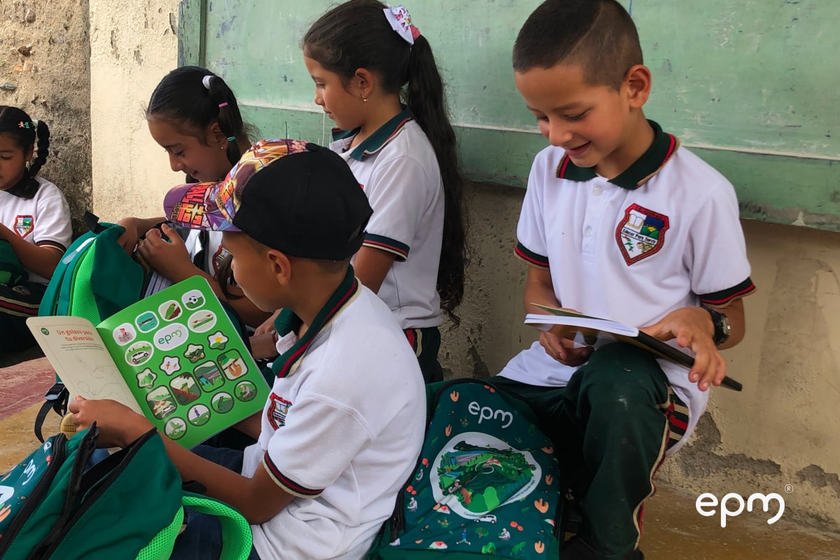 Niños abriendo los kits escolares entregados por EPM