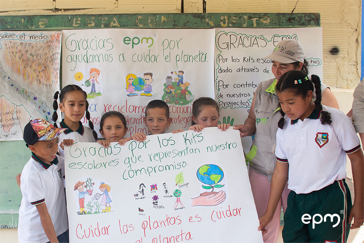 Grupo de niños sosteniendo un cartel con un mensaje agradeciendo a EPM por la entrega de los Kits escolares