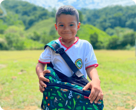 Niño feliz, sosteniendo la maleta del kit escolar epm