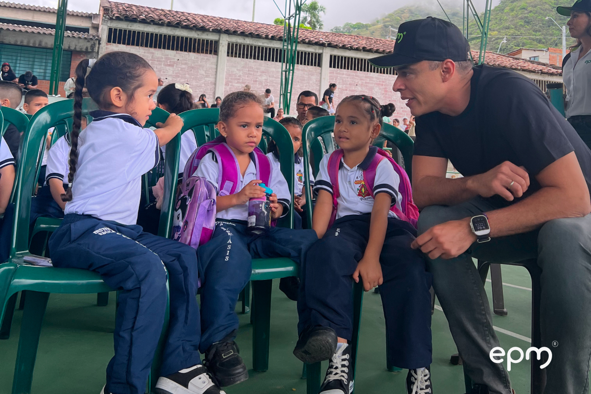 Persona de EPM compartiendo con niños durante entrega de kits escolares en el municipio de Liborina