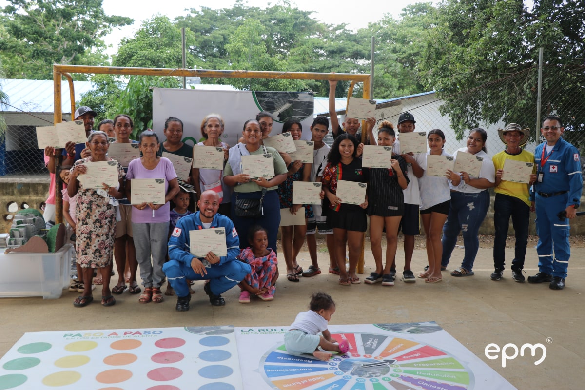 Comunidad recibe certificado de participación y posan para una fotografía