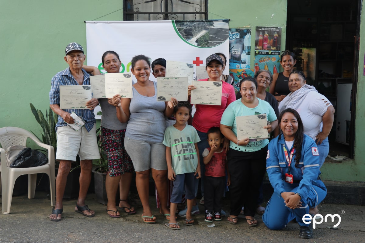 Comunidad recibe certificado de participación y posan para una fotografía