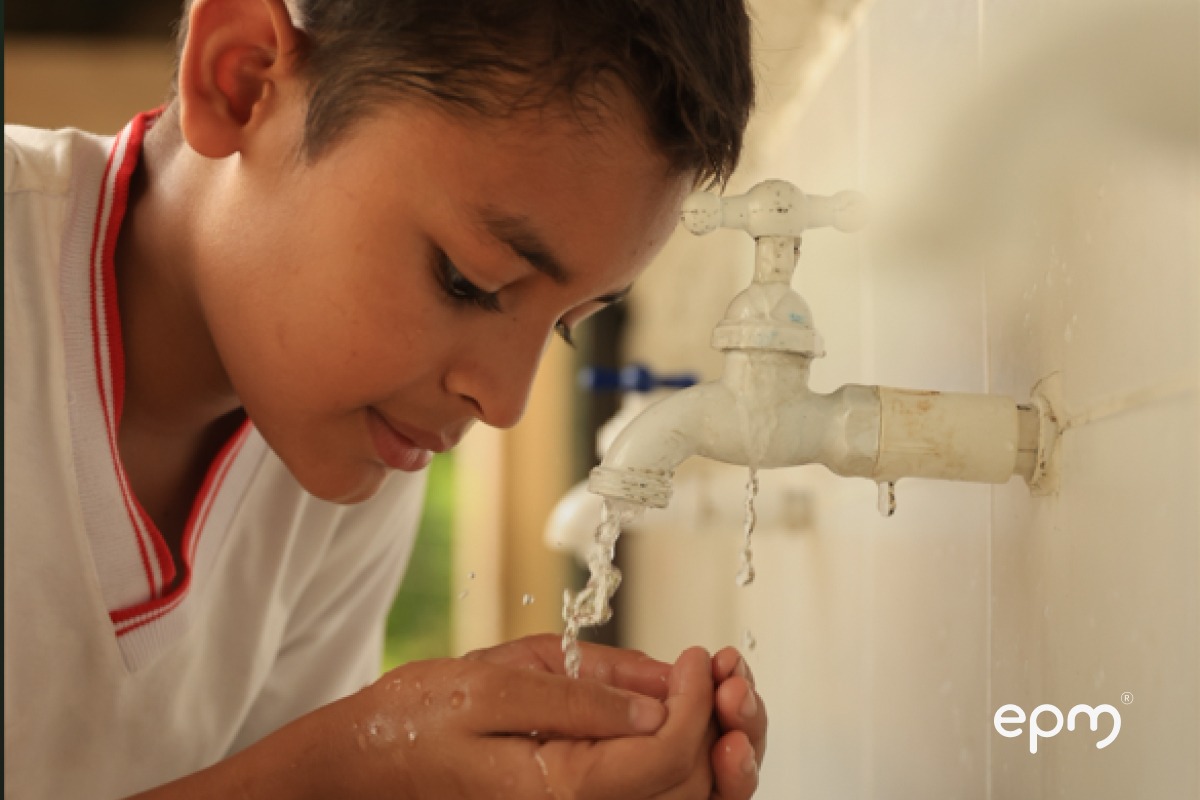 Fotografía de niño bebiendo agua de una llave 
